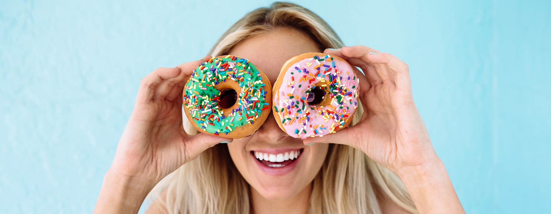 Woman posing with doughnuts around her eyes